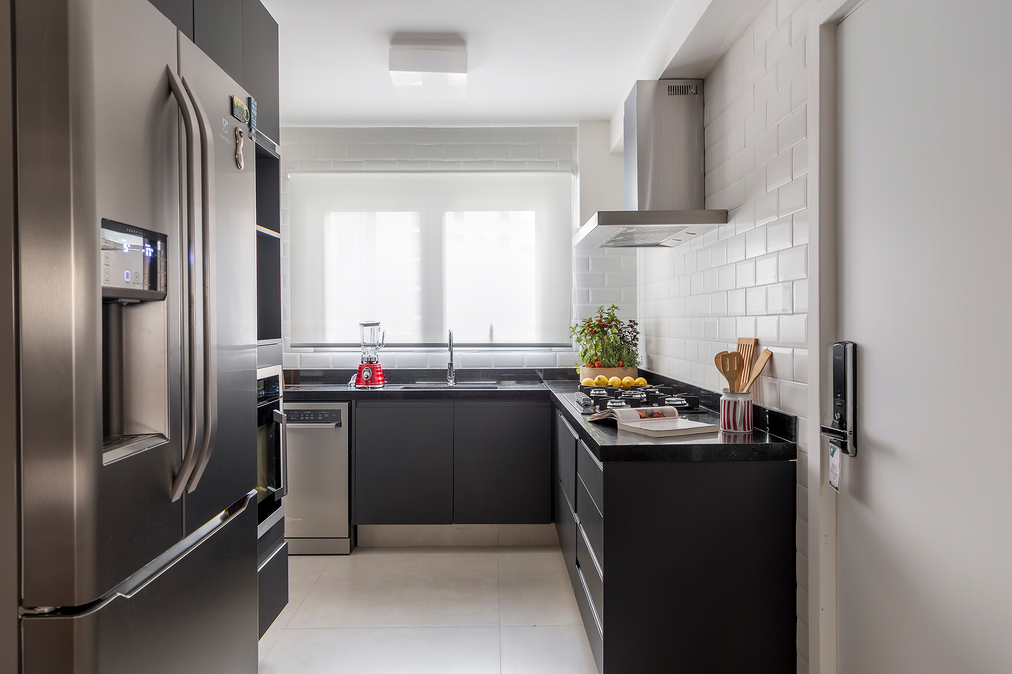 Paola Ribeiro assina apartamento de 196 m² com alma carioca em SP. Projeto de Paola Ribeiro, Na foto, cozinha co marcenaria preta e torre quente.