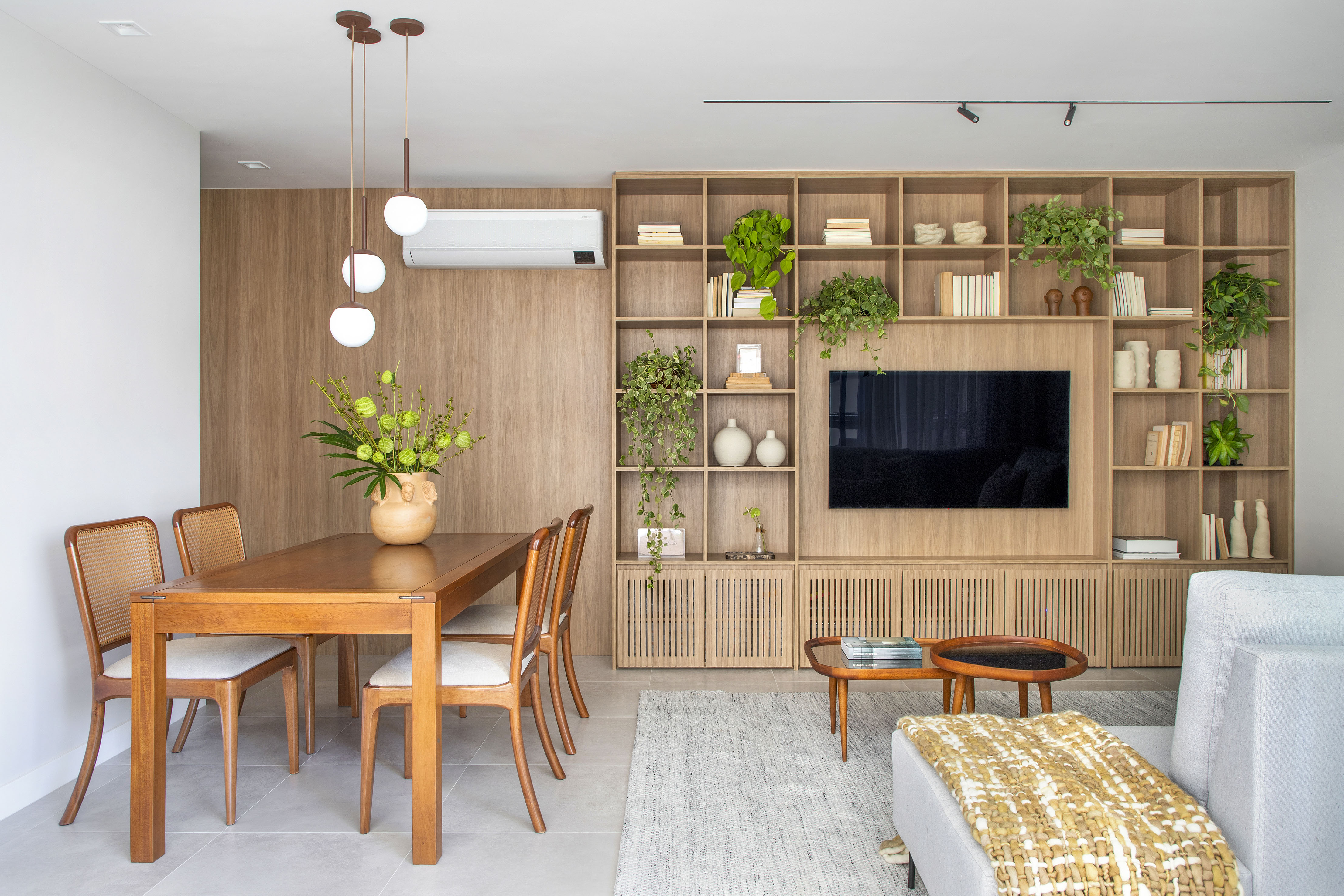 Sem quebra-quebra, apê de 92 m² ganha projeto afetivo e com biofilia. Projeto de Fabiano Ravaglia. Na foto, sala de jantar com tv e estante.