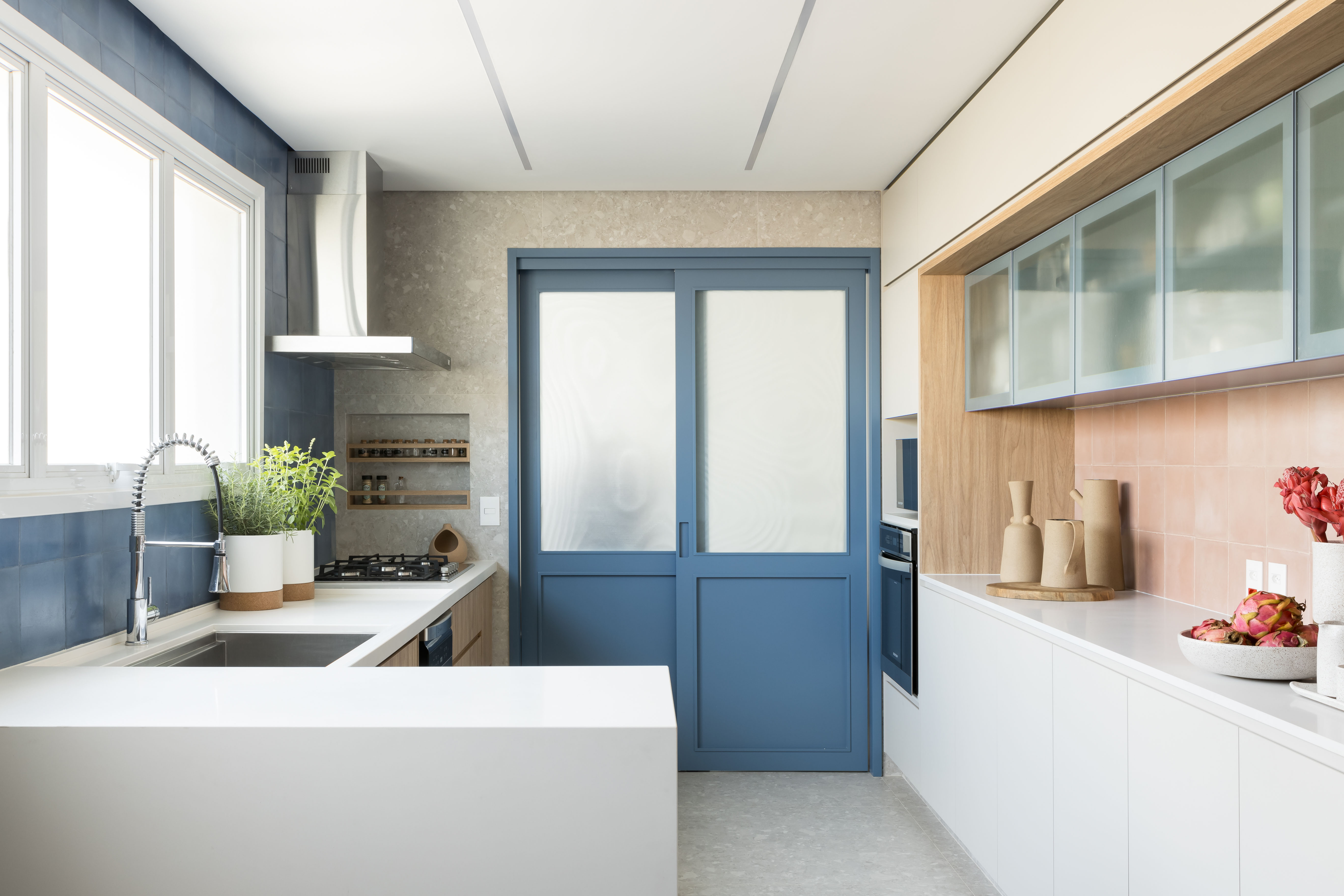 Apê eclético: minimalismo, shabby chic e industrial se mesclam em 180 m². Projeto Studio Lak. Na foto, cozinha com bancada e porta azul.
