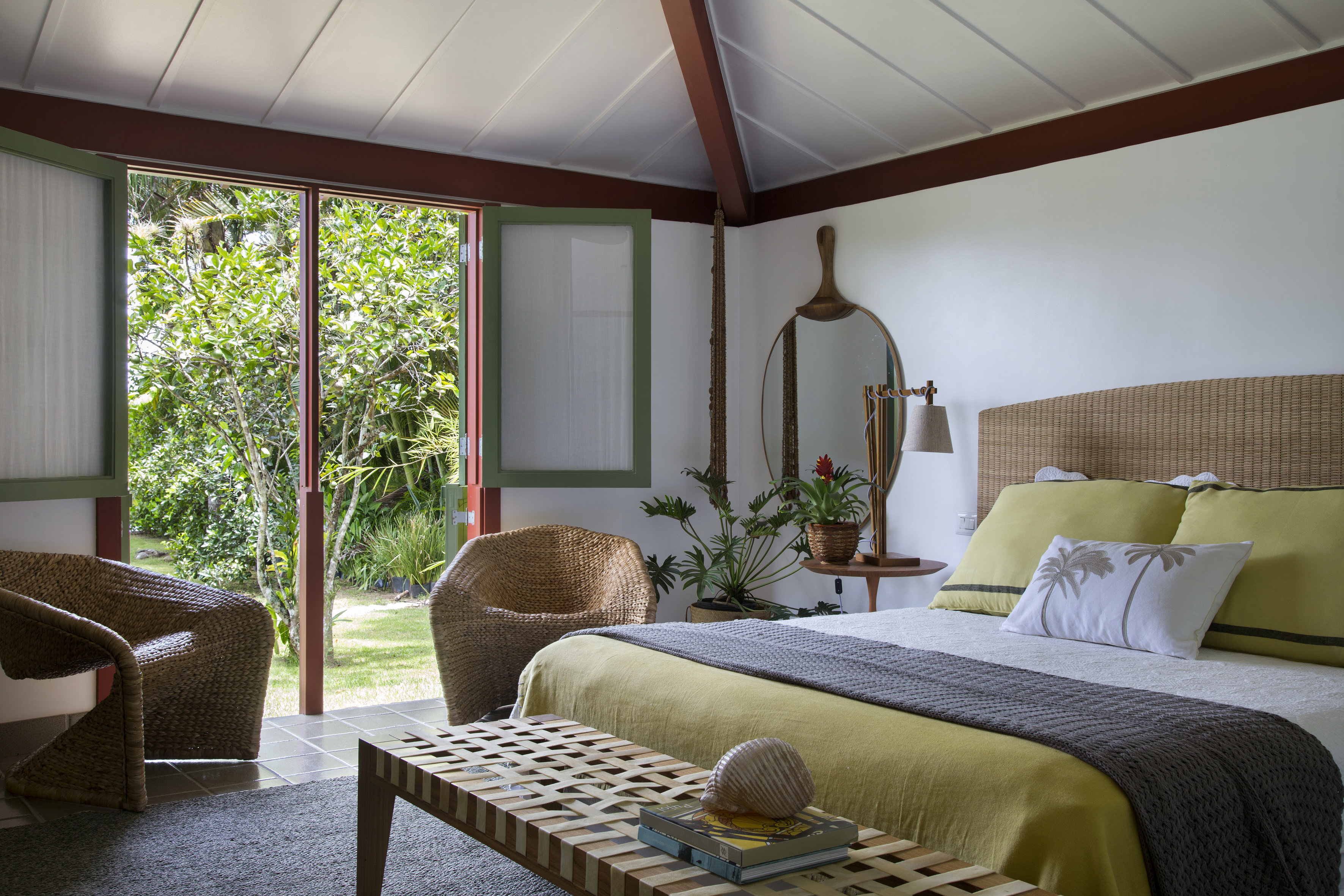 Casa com vista para o mar e nove suítes ganha nova varanda na reforma. Projeto de Escala Arquitetura. Na foto, quarto de casal com cabeceira de fibra e poltrona.