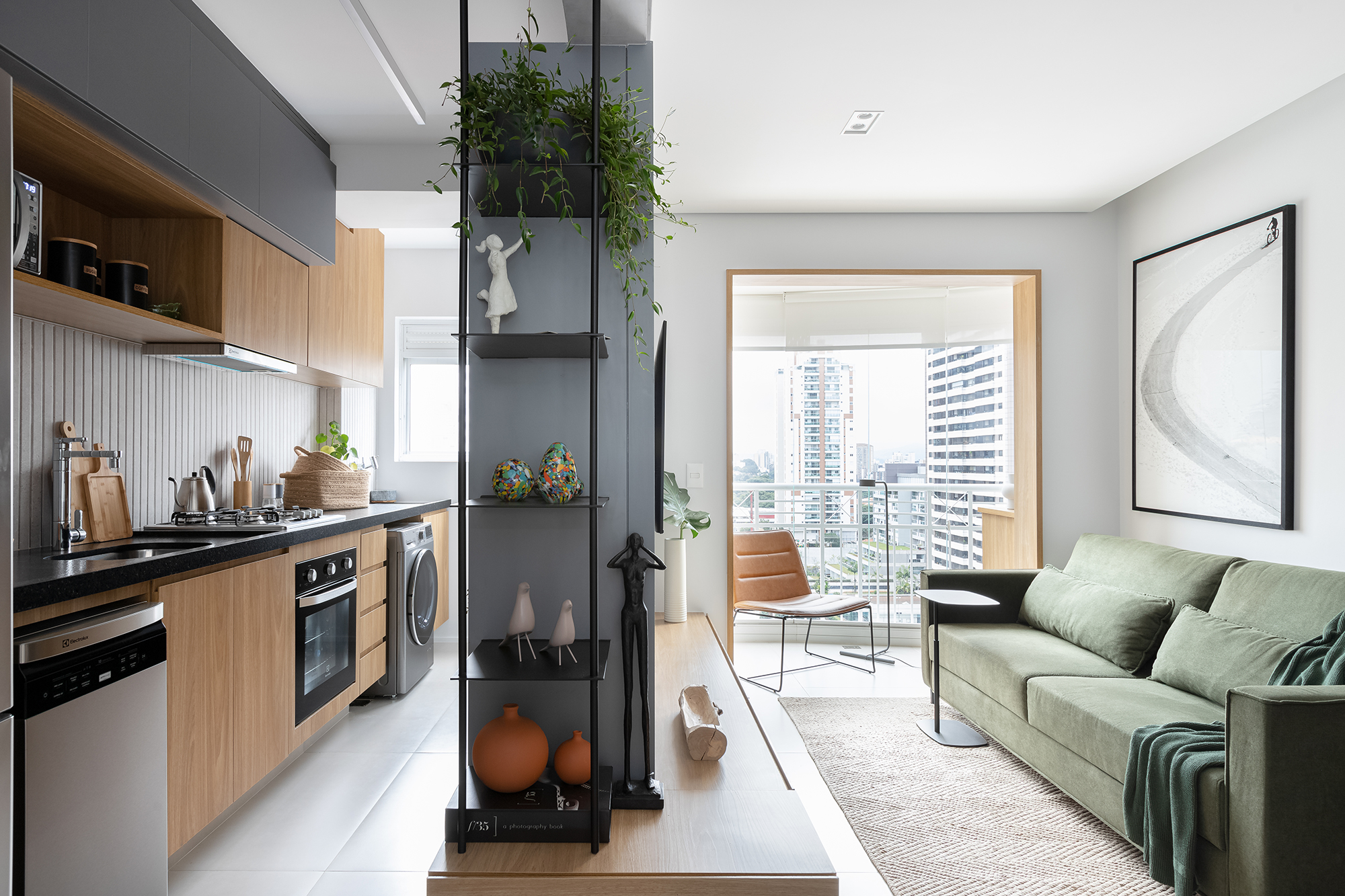 Estilo japandi permeia todo o décor deste apartamento de apenas 53 m². Projeto de Studio Monfré, Na foto, sala de estar e jantar integradas e estante vazada. Cozinha com lavanderia.