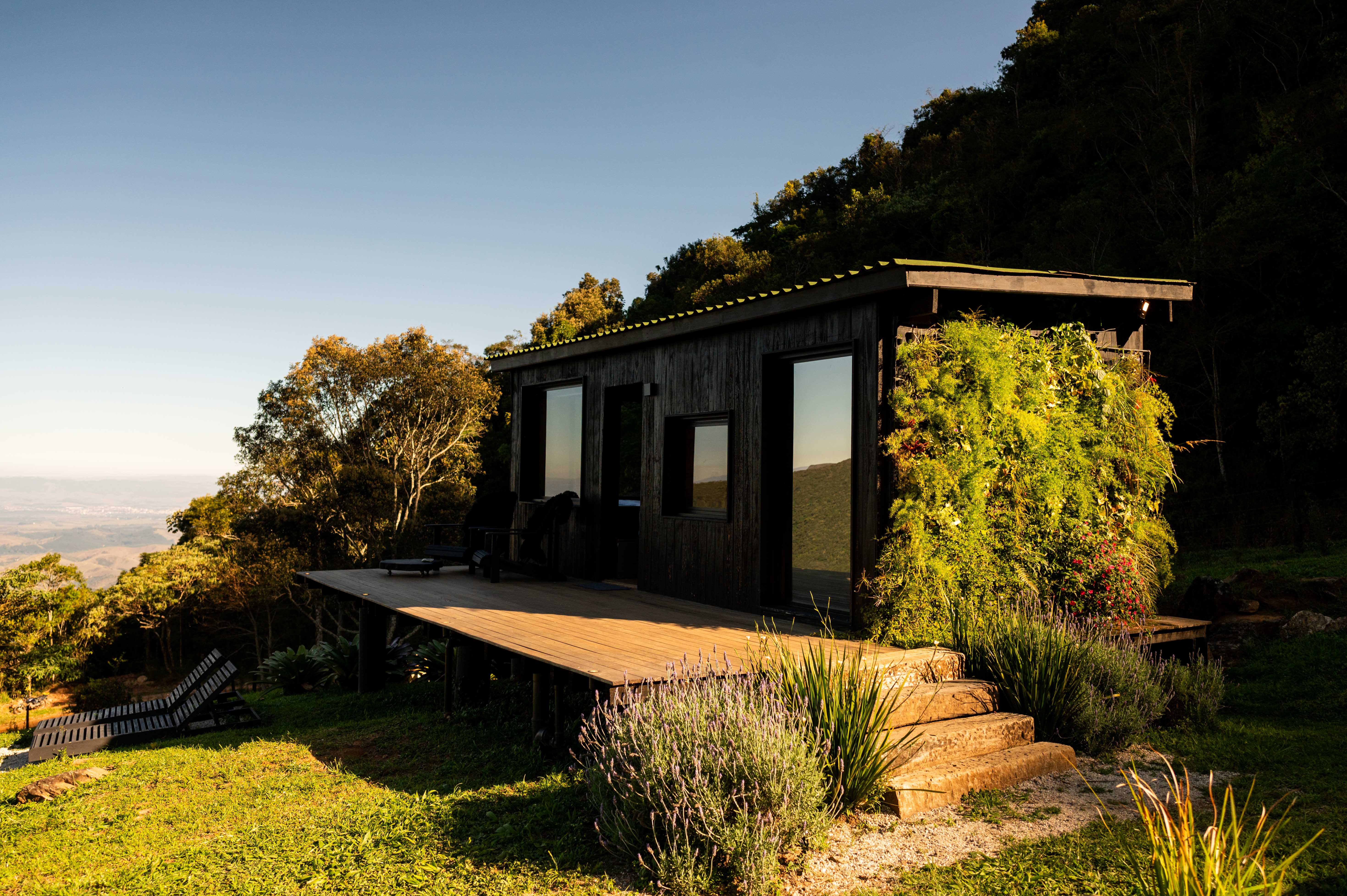 Tiny house sustentável fica a 1500 m de altitude na região serrana de SP. Projeto de Ricardo Delgallo. Na foto, fachada da casa em meio às montanhas.