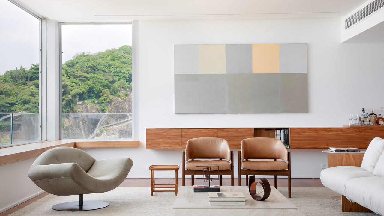 À beira-mar, apartamento minimalista ganha ares de galeria de arte. Projeto de João Panaggio. Na foto, sala de estar com quadro, aparador-bar, poltronas e sofá.