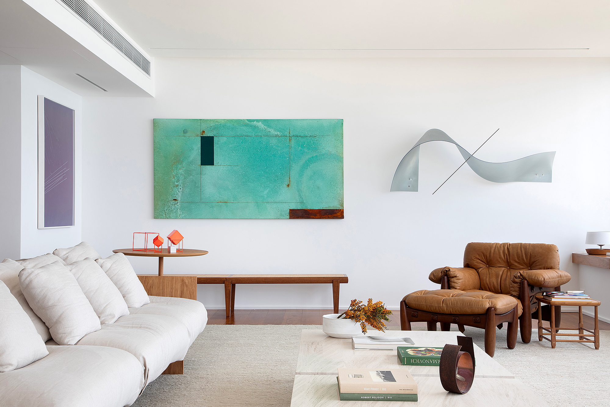 À beira-mar, apartamento minimalista ganha ares de galeria de arte. Projeto de João Panaggio. Na foto, sala de estar com quadro, poltrona mole e aparador.