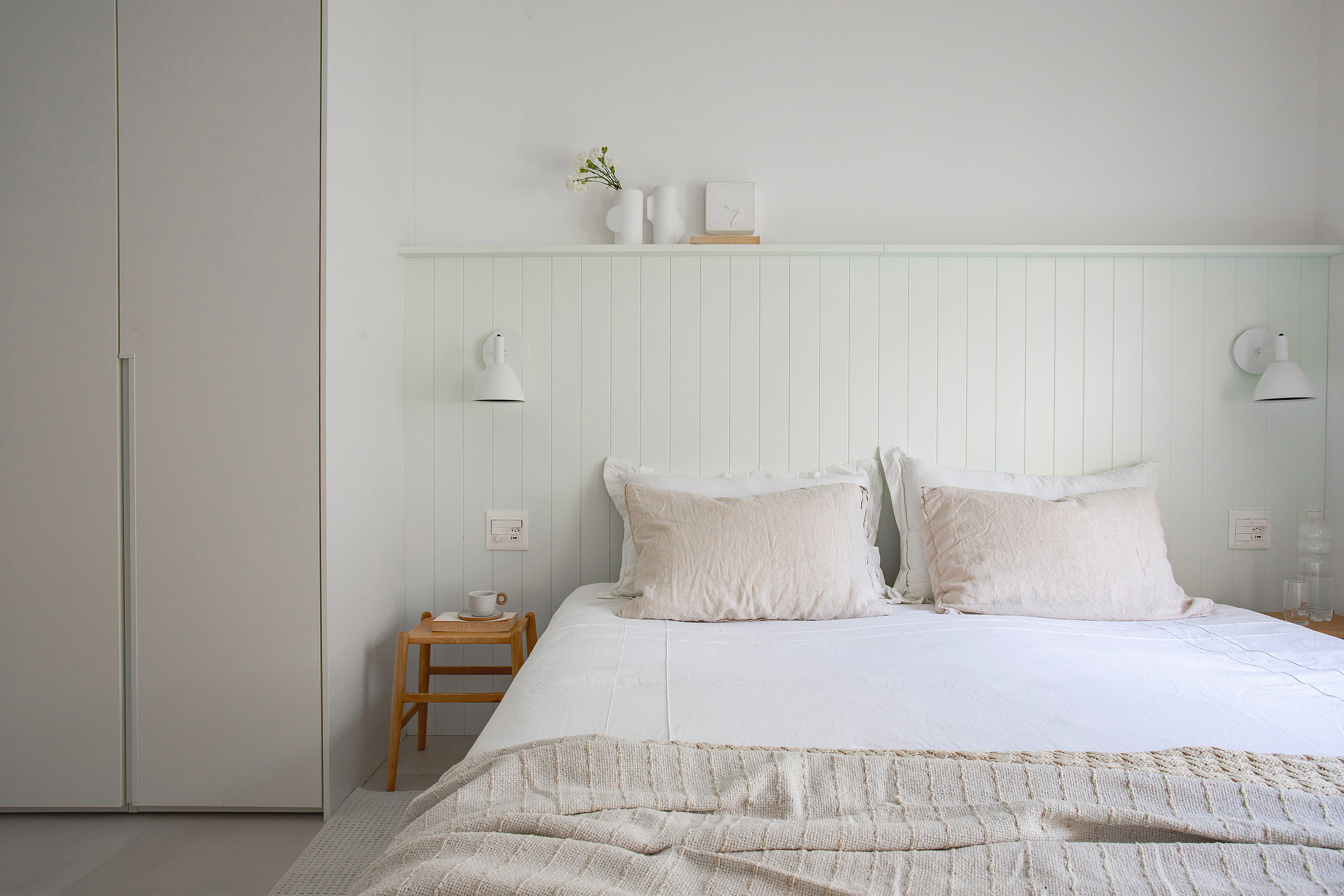 Casal de ingleses troca a casa na Inglaterra por apê minimalista no Rio. Projeto da arquiteta Natalia Lemos. Na foto, quarto de casal com cabeceira de madeira e cortinas.