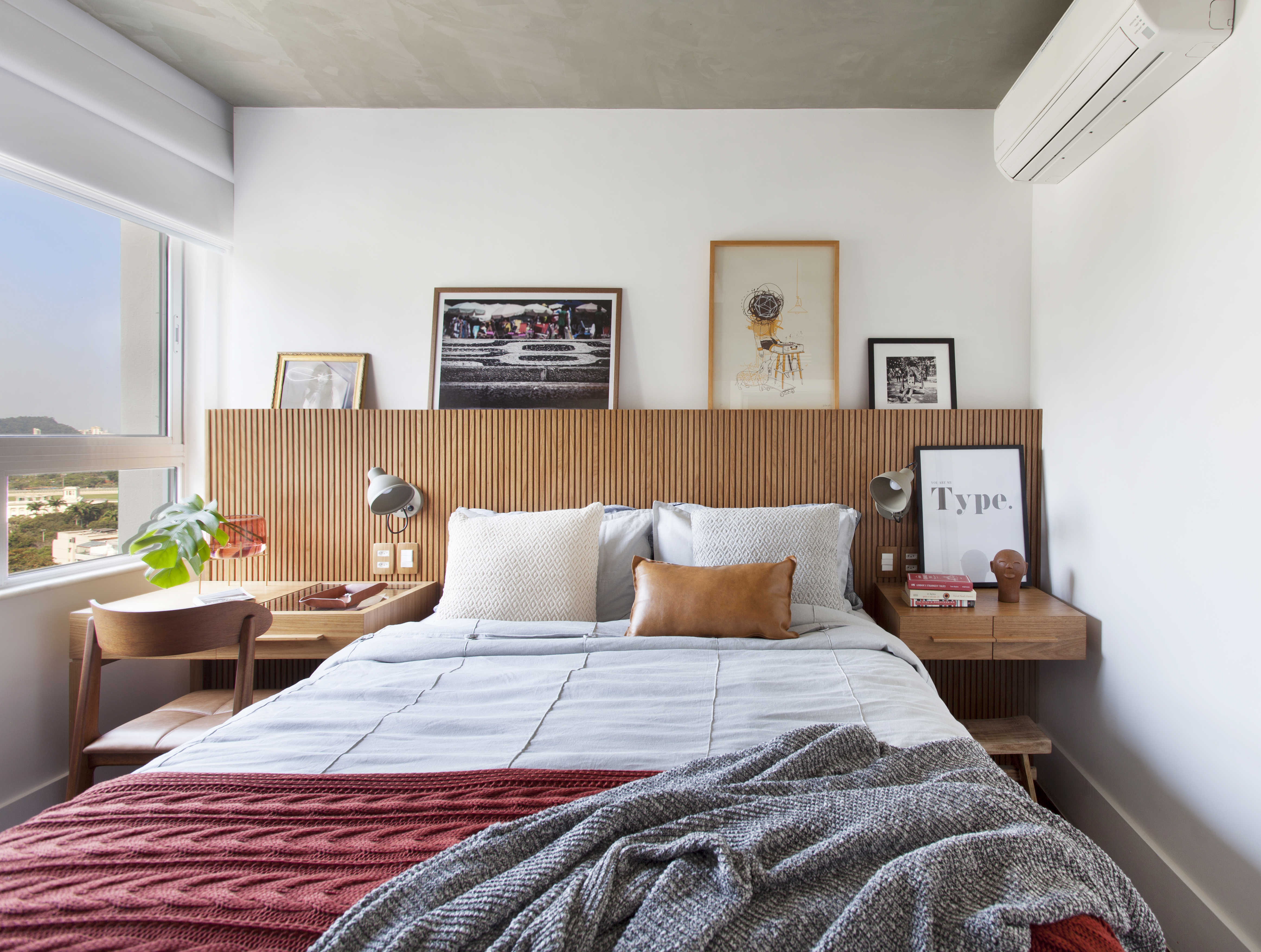 Apê de 150 m² une decoração descolada e vista para a Lagoa. Projeto de Manuela Santos. Na foto, quarto de casal com cabeceira ripada e quadros.