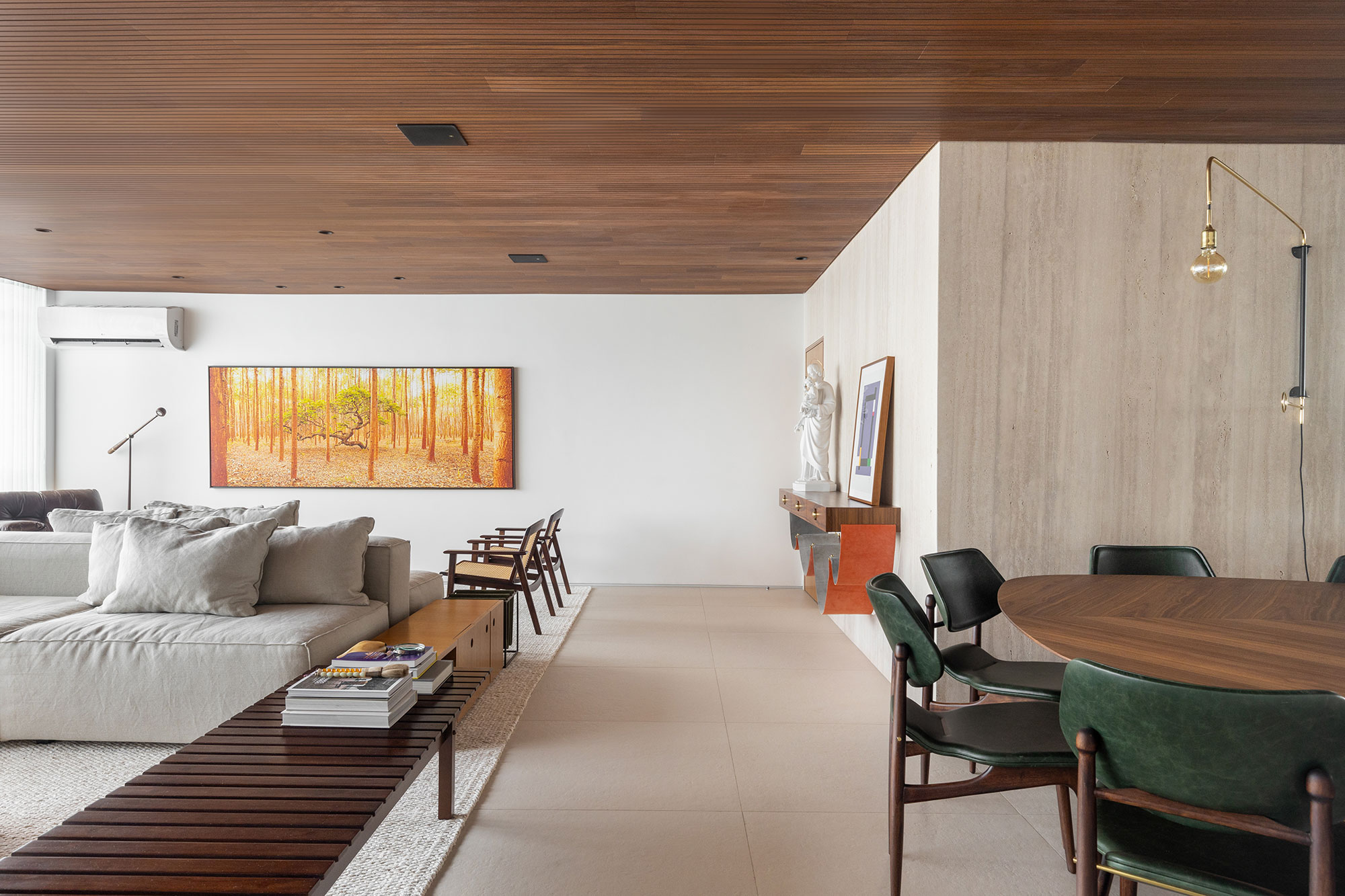 Arquitetura modernista e mobiliário brasileiro se unem neste apartamento. Projeto de Maria Araujo. Na foto, sala com mesa de jantar, quadro e banco.