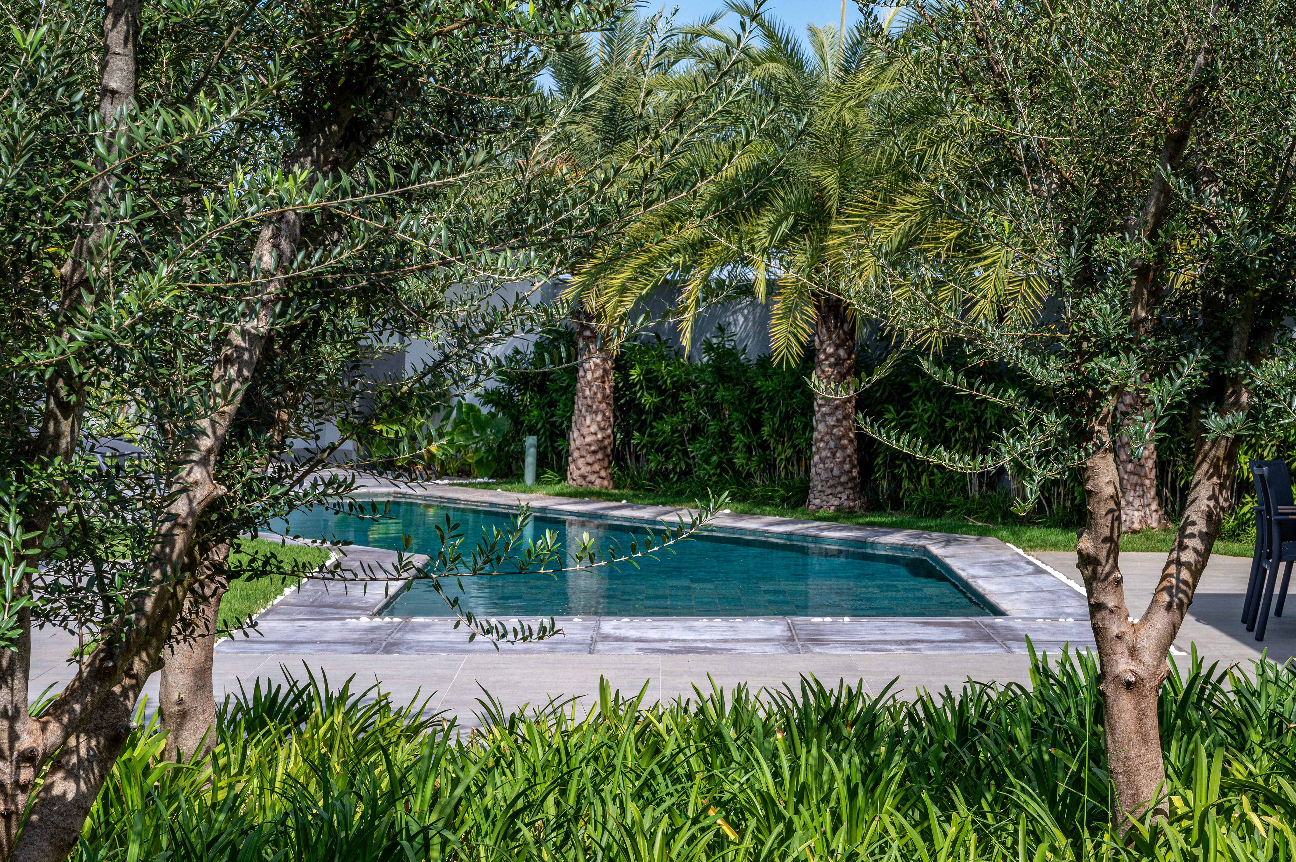 Jardim de 1710 m² ganha pista de caminhada e paisagismo tropical. Projeto de Flávia D´Urso. Na foto, fachada com jardim e piscina.