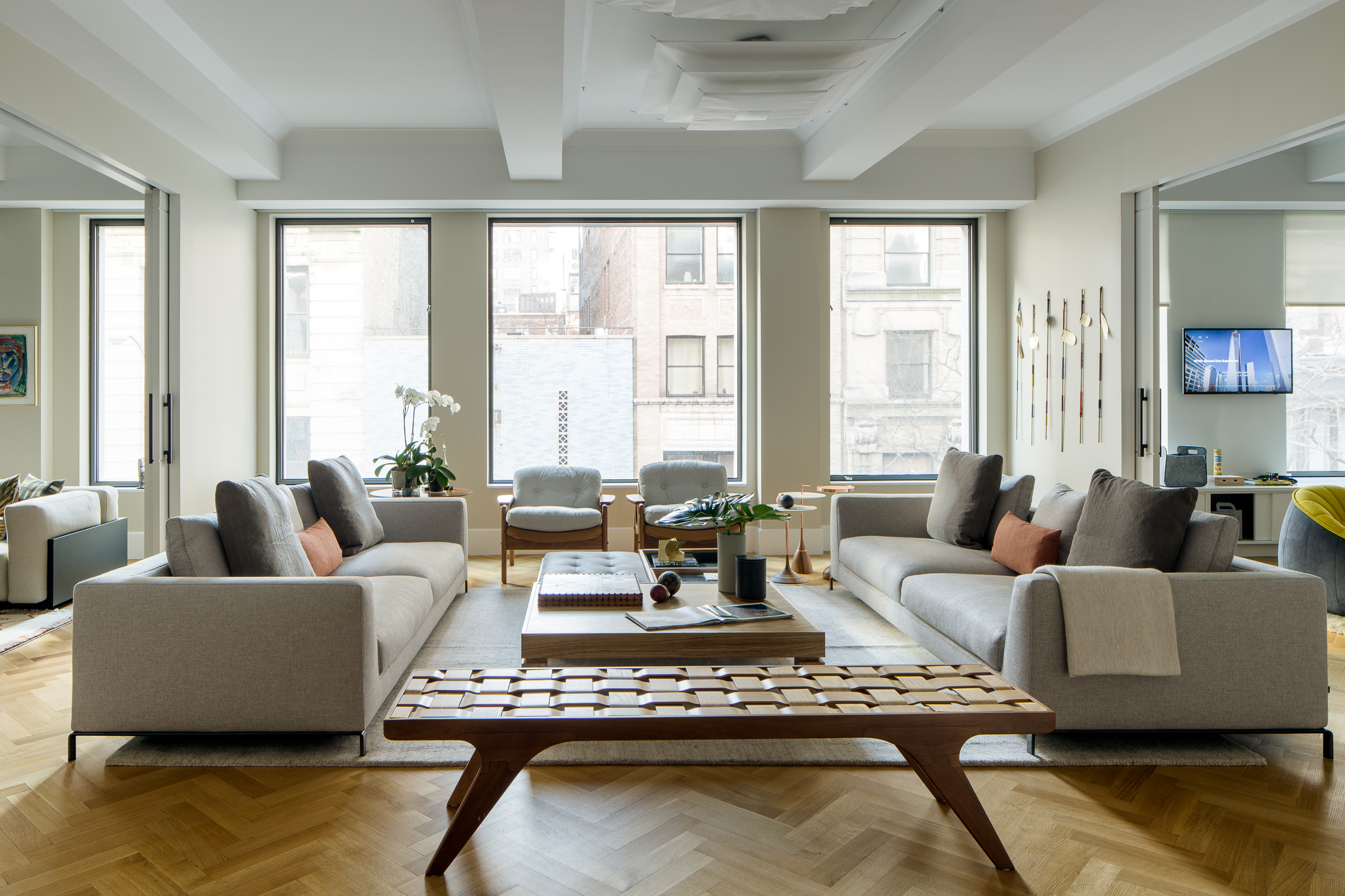 Apartamento em Nova York tem décor repleto de design brasileiro. Projeto de Maurício Nóbrega. Na foto, sala com grandes janelas e sofás.