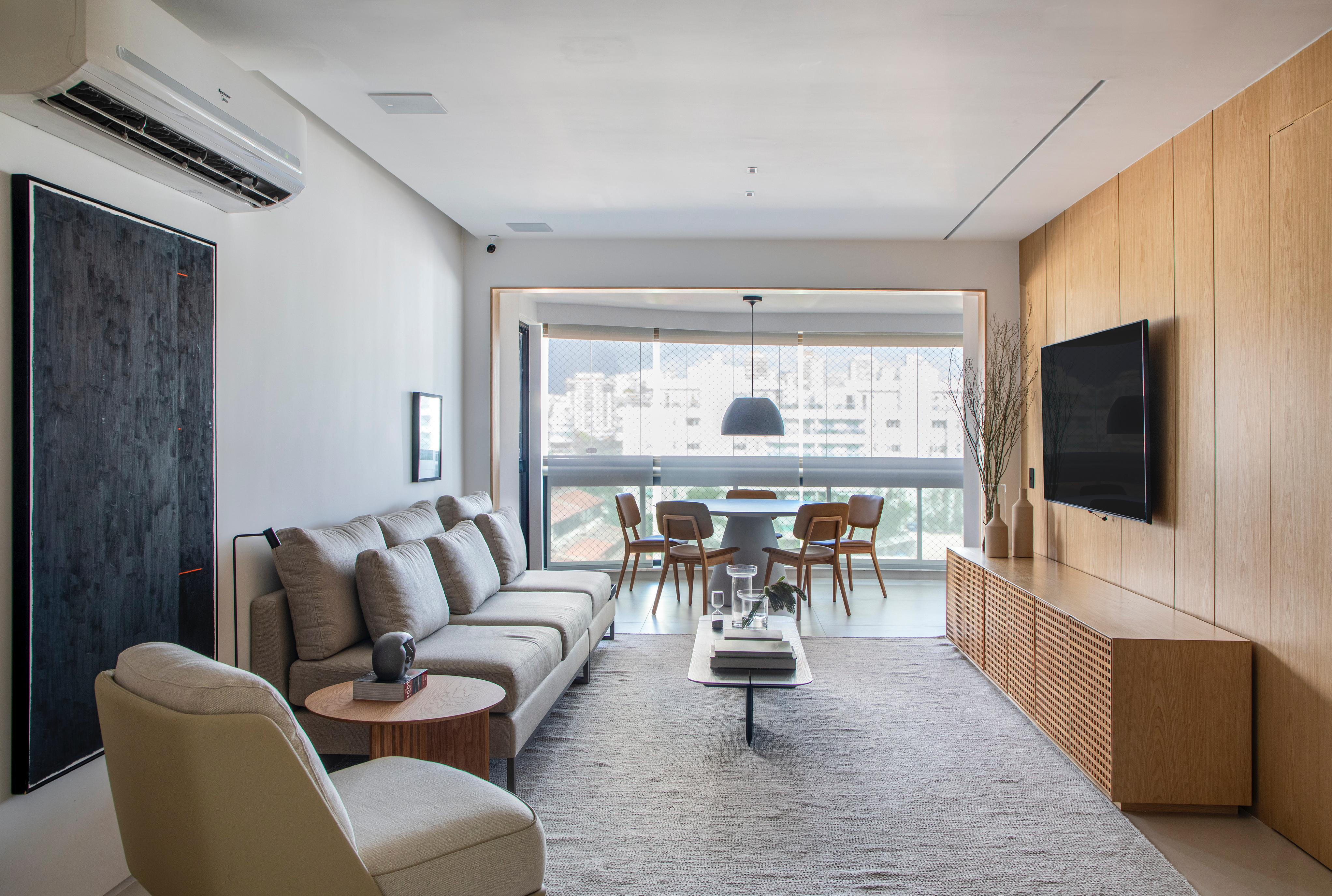 Apê de 200 m² ganha décor minimalista em tons de branco, cinza e bege. Projeto de Fabio Bouillet e Carol Freitas. Na foto, sala com sofá, poltrona e tapete.
