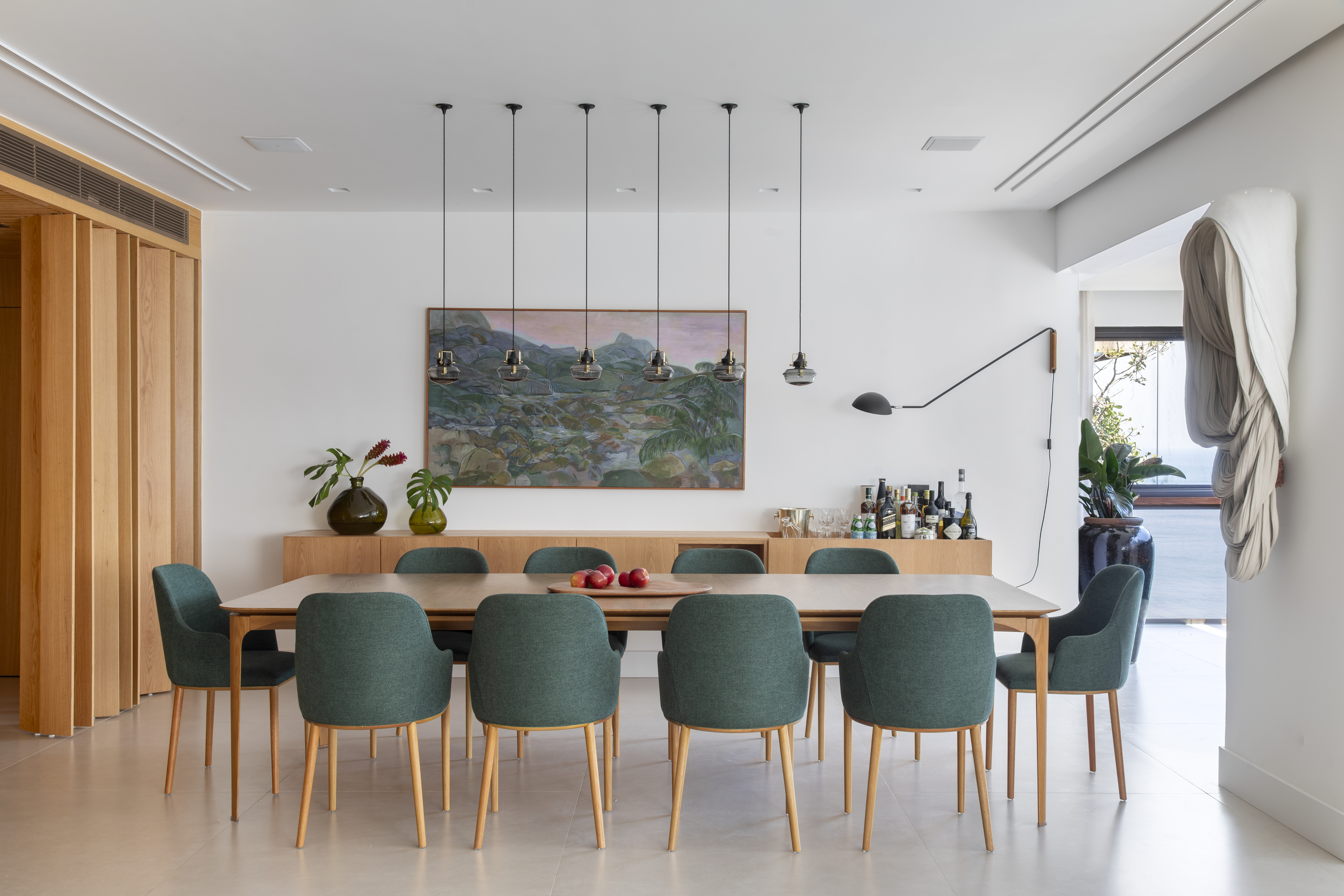 Cobertura ganha estar e gourmet com vista para a Pedra da Gávea. Projeto de Studio 021 Arquitetura. Na foto, sala de jantar com parede de madeira.