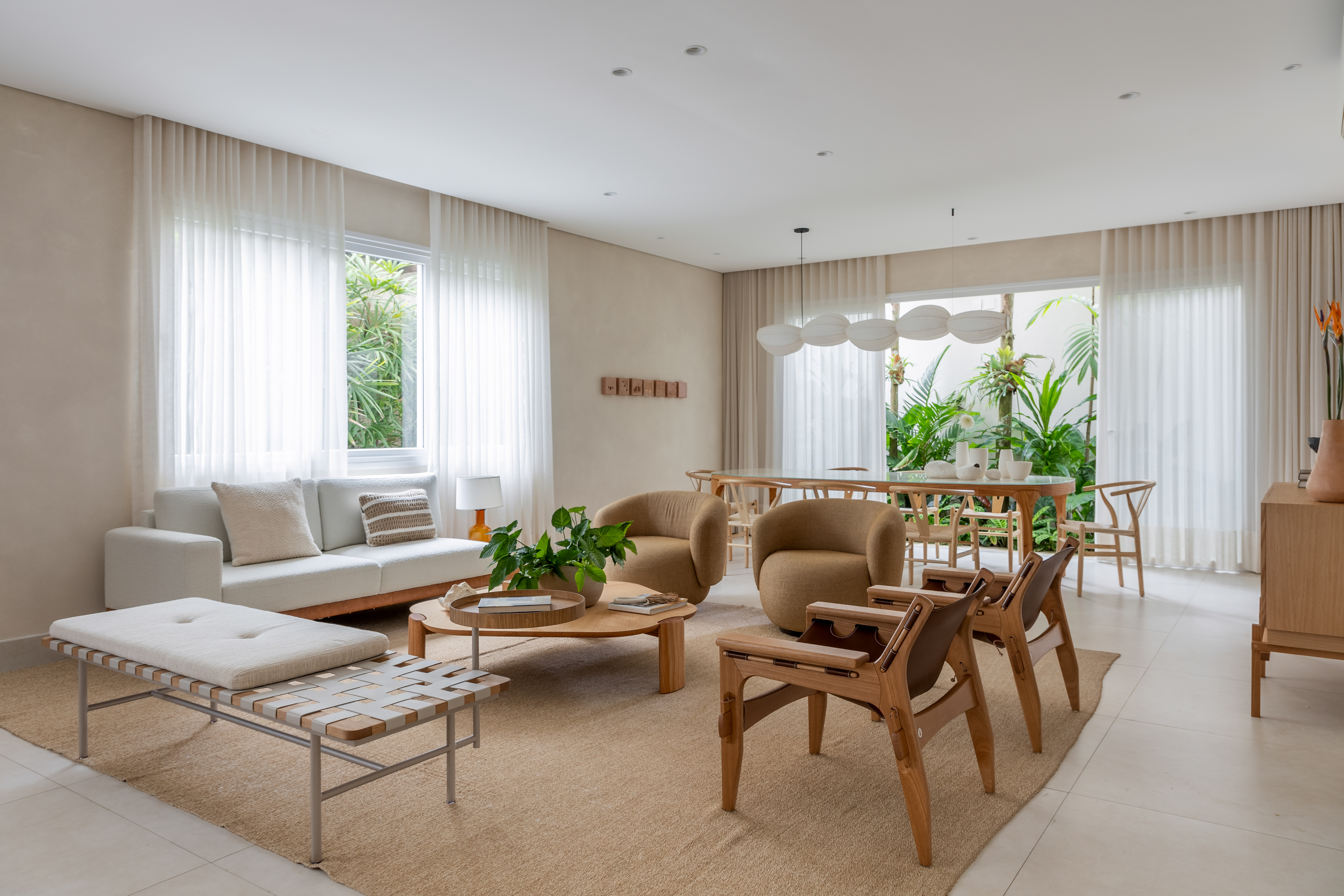 Casa de praia ganha décor fresh, com cores claras e tons neutros. Projeto de Beatriz Quinelato. Na foto, sala de estar com tv, aparador de cerâmica e mesa.