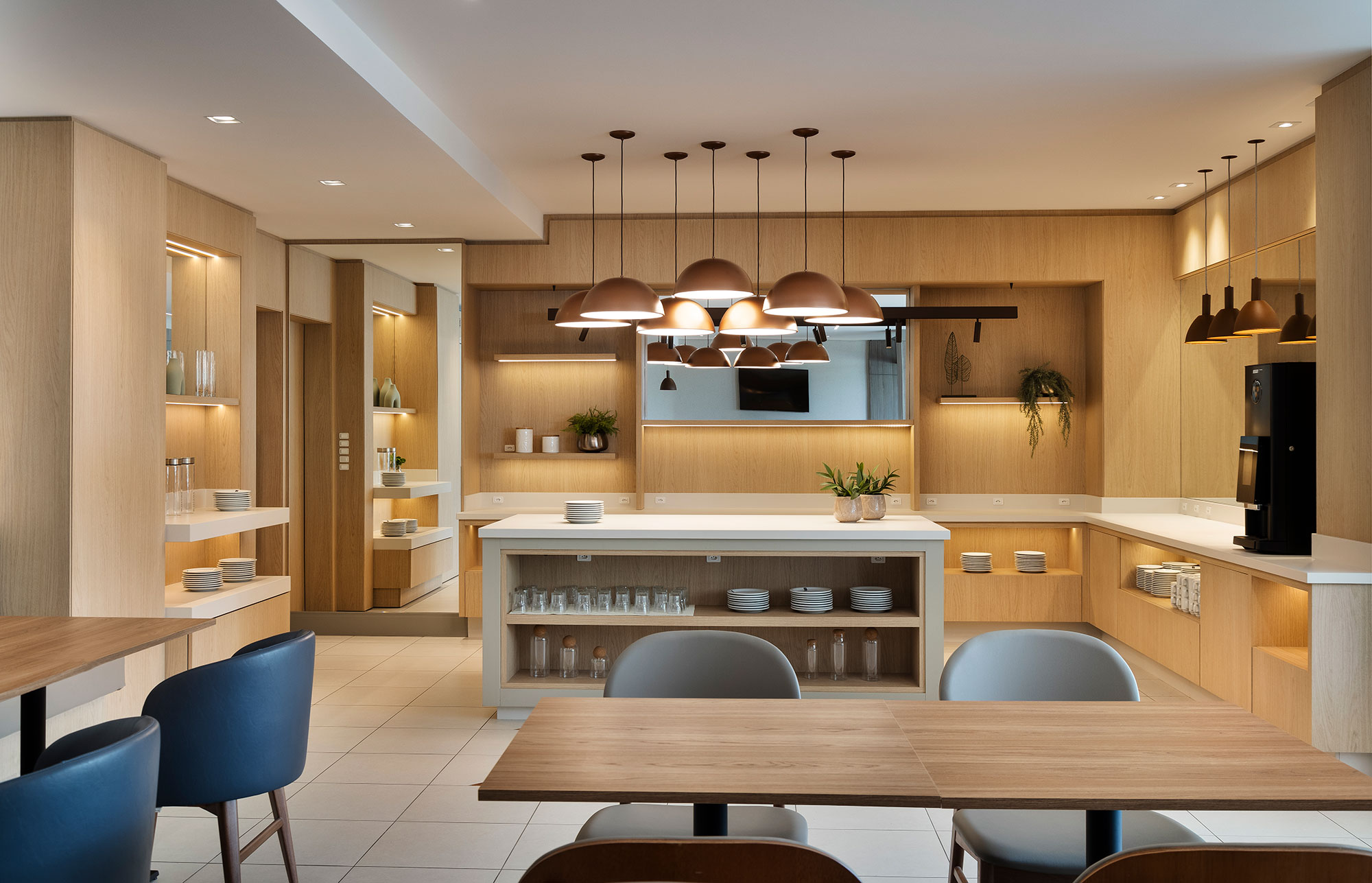 Hotel é pensado para atender turistas e hóspedes em viagens de trabalho. Projeto de Estela Cislaghi. Na foto, espaço gourmet com ilha e bancos.