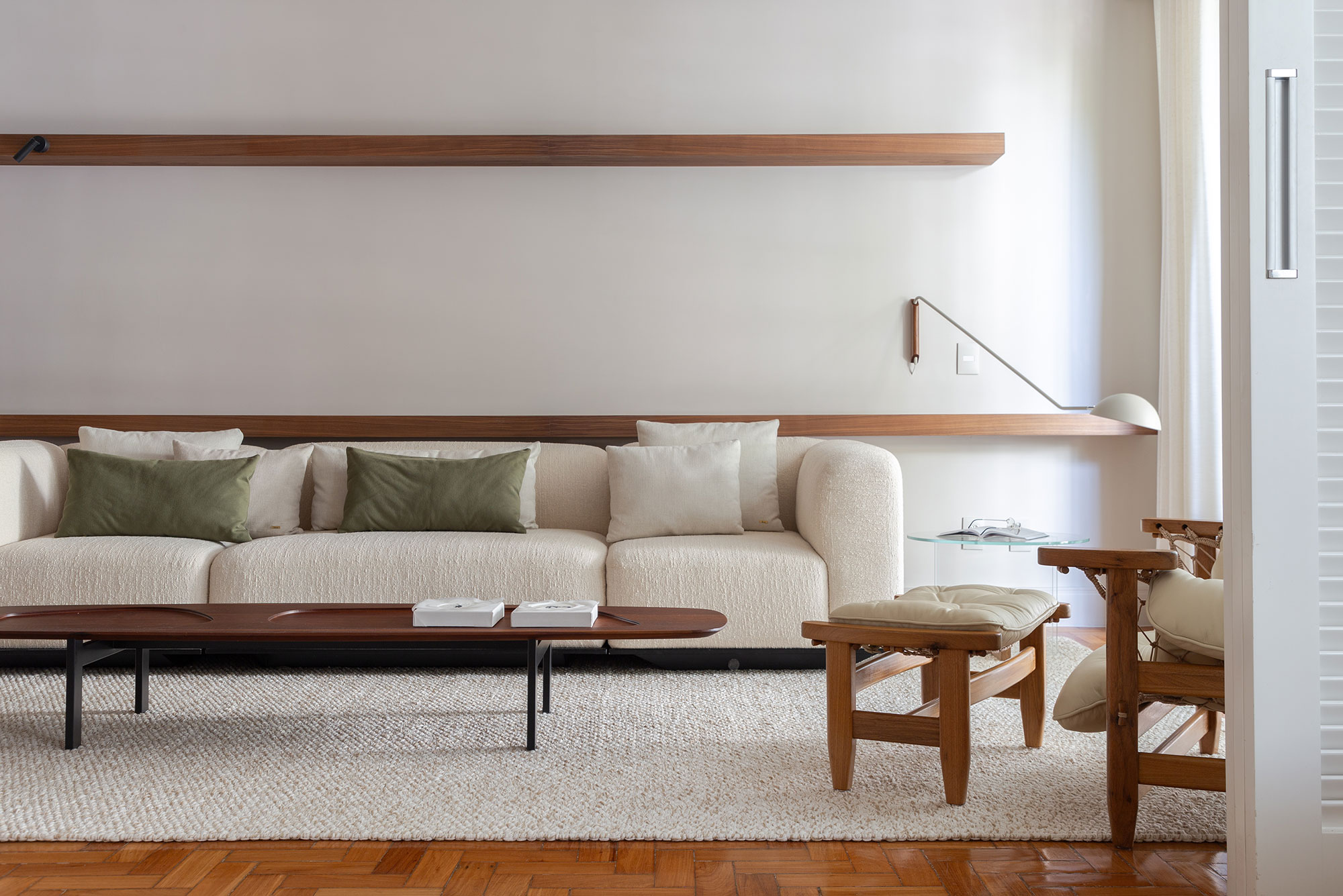 Minimalismo, tons pastel e móveis de design marcam apê de empresária. Projeto de Quintino Facci. Na foto, sala de estar com sofá branco e tapete.