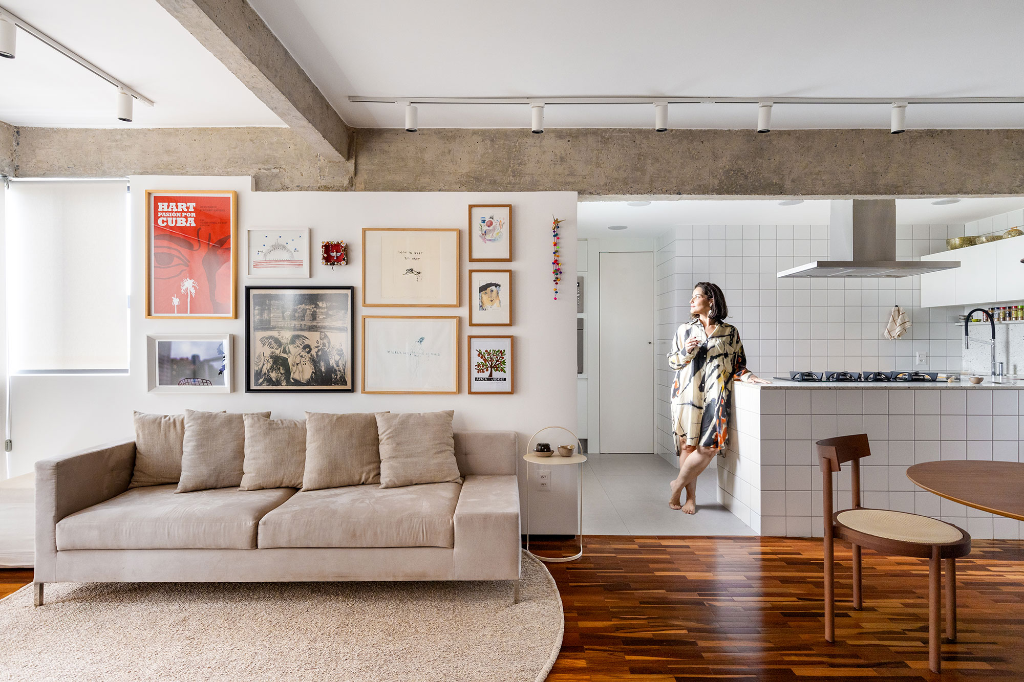 Reforma valoriza estrutura original de apê de 68 m² em Brasília. Projeto de Bloco Arquitetos. Na foto, sala com coluna estrutural, aparador de azulejos e quadros.