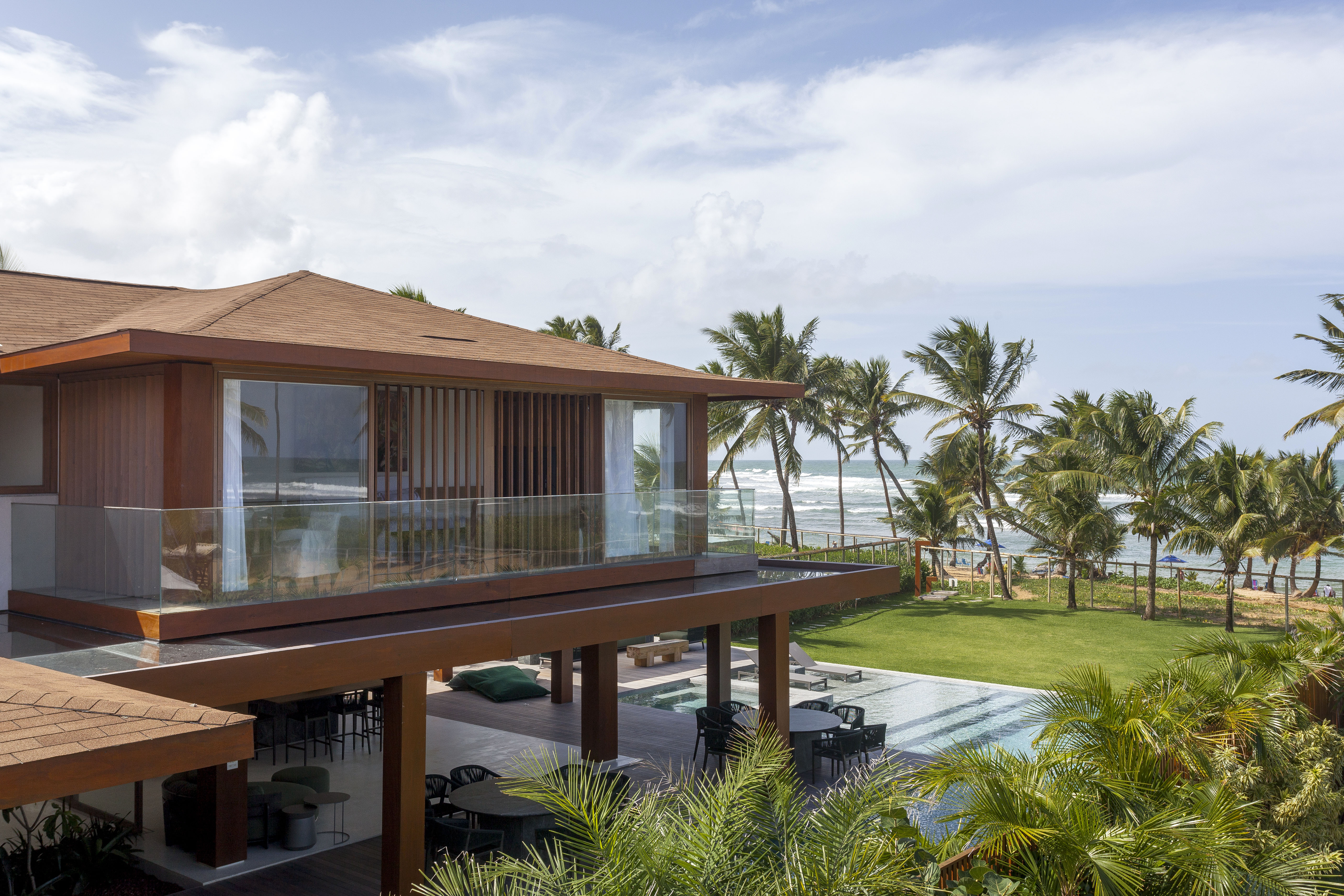 Na Praia do Forte, refúgio de 518 m² integra arquitetura e natureza. Projeto de David Bastos. Na foto, fachada com piscina e jardim.