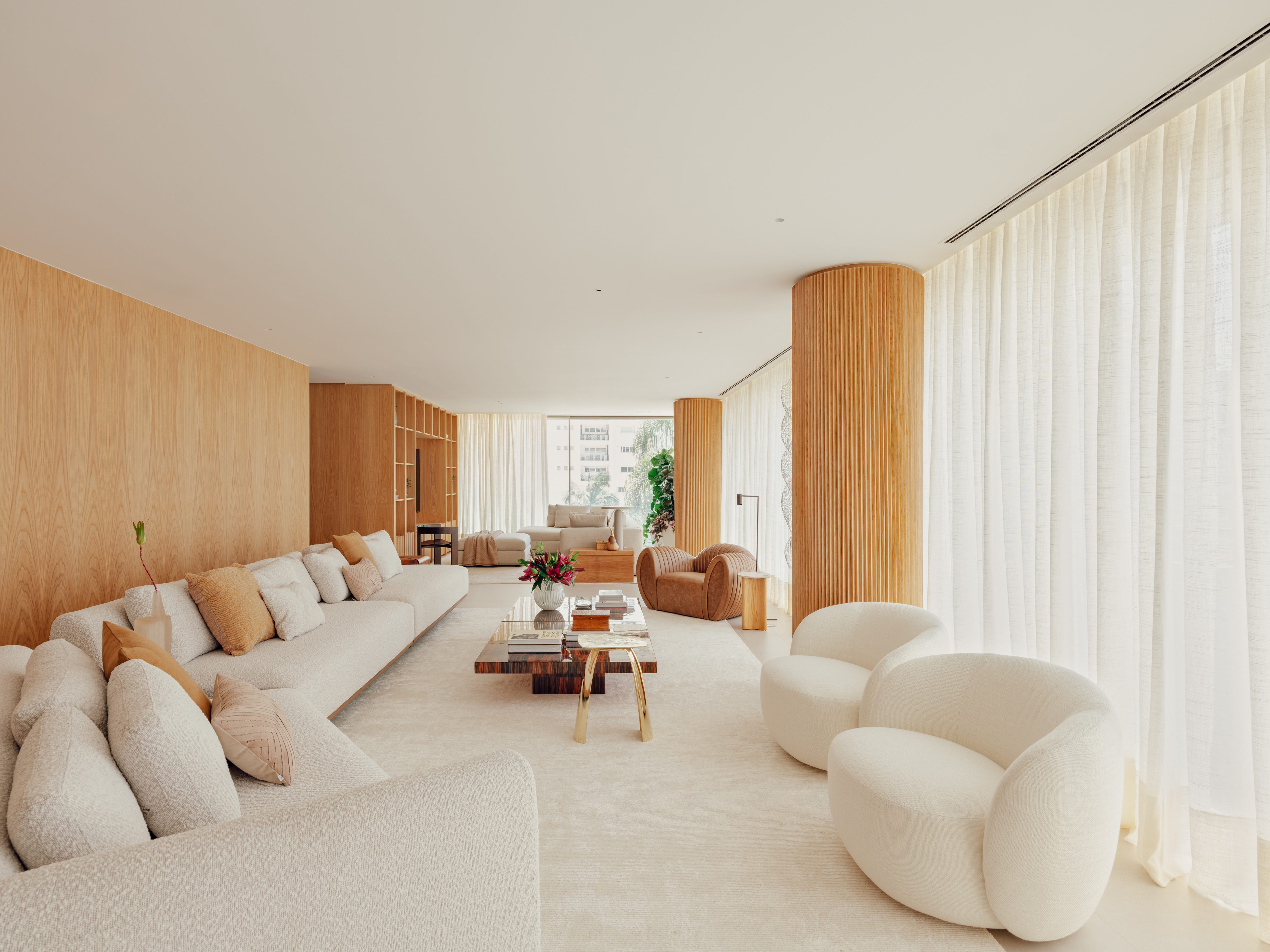 Apê de 350 m² mistura referências nova-iorquinas e brasilidades no décor. Projeto de Barbara Dundes. Na foto, sala com sofá e pilares.