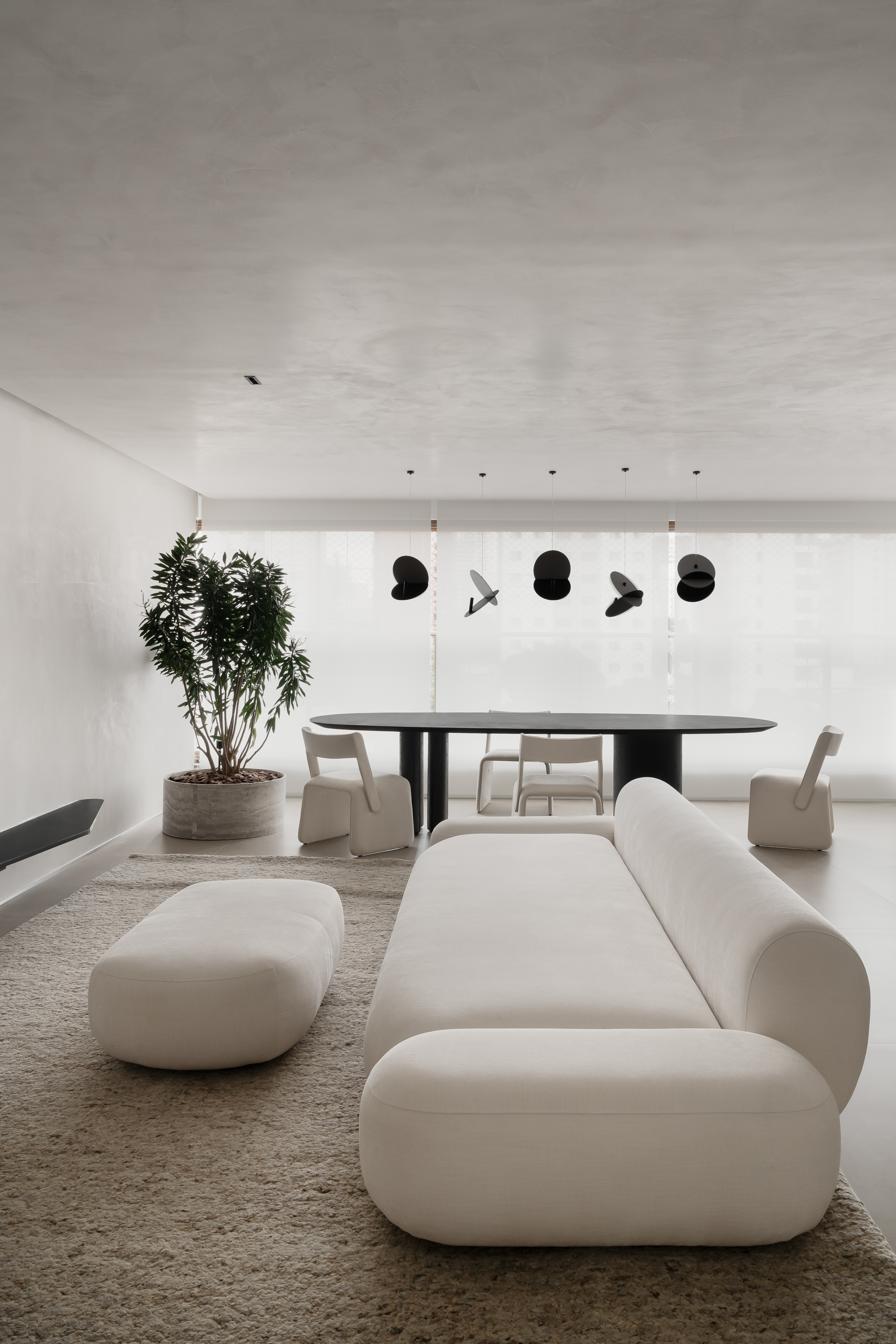 Com décor preto e branco, apê de 110 m² se adapta para a chegada do bebê. Projeto de Natan Gil. Na foto, sala com poltrona branca e mesa de jantar.