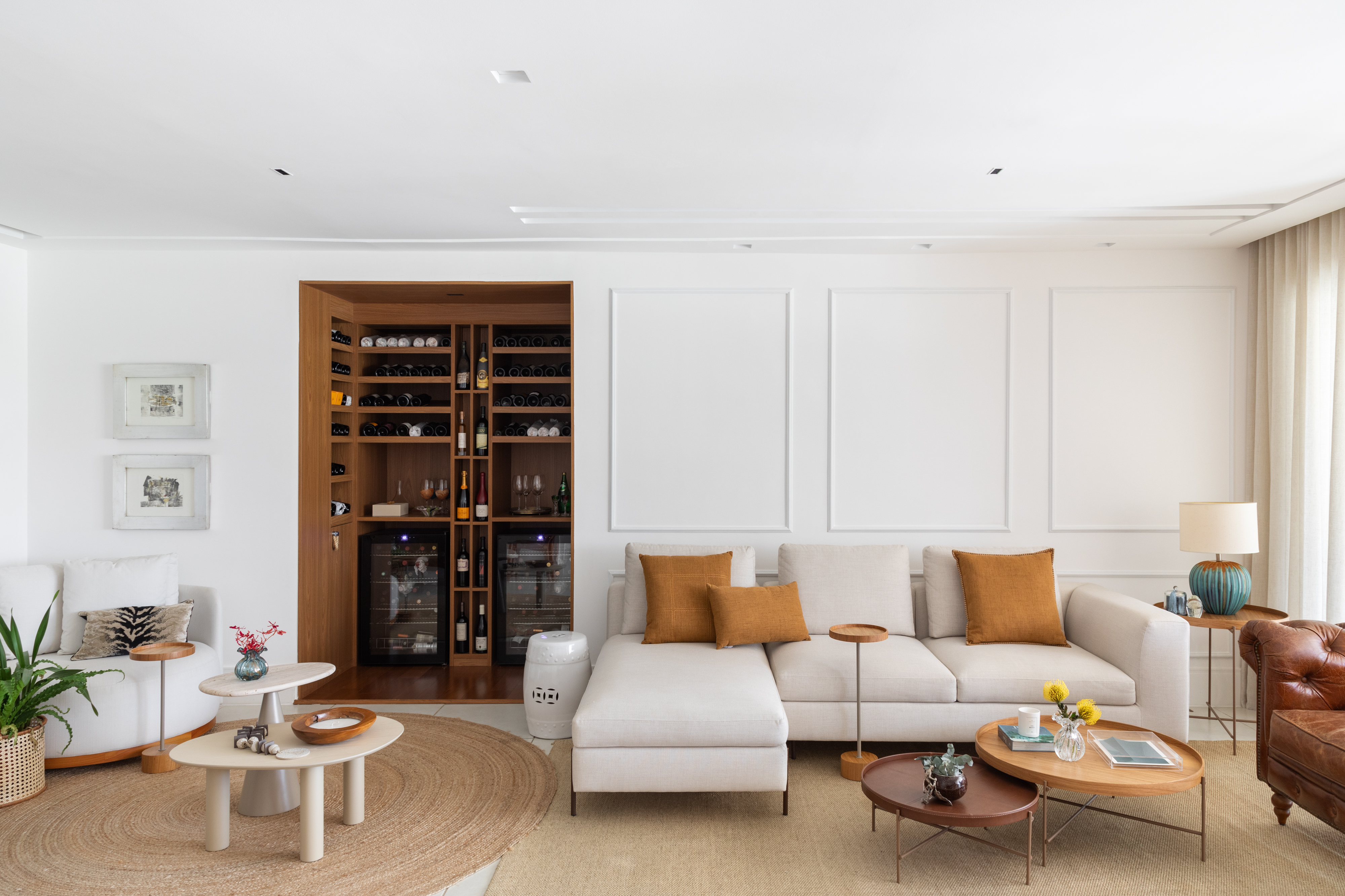 Sem quebra-quebra, apartamento de 185 m² ganha adega e closet walk-in. Projeto de Vivian Reimers. Na foto, sala com adega e sofás.