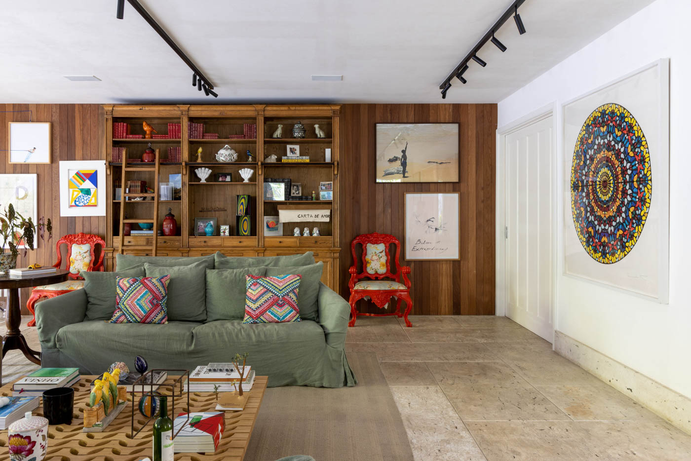 Com seis suítes, reforma adequa casa de 647 m² à rotina da família. Projeto de Maurício Nóbrega. Na foto, sala estantes e sofá verde.