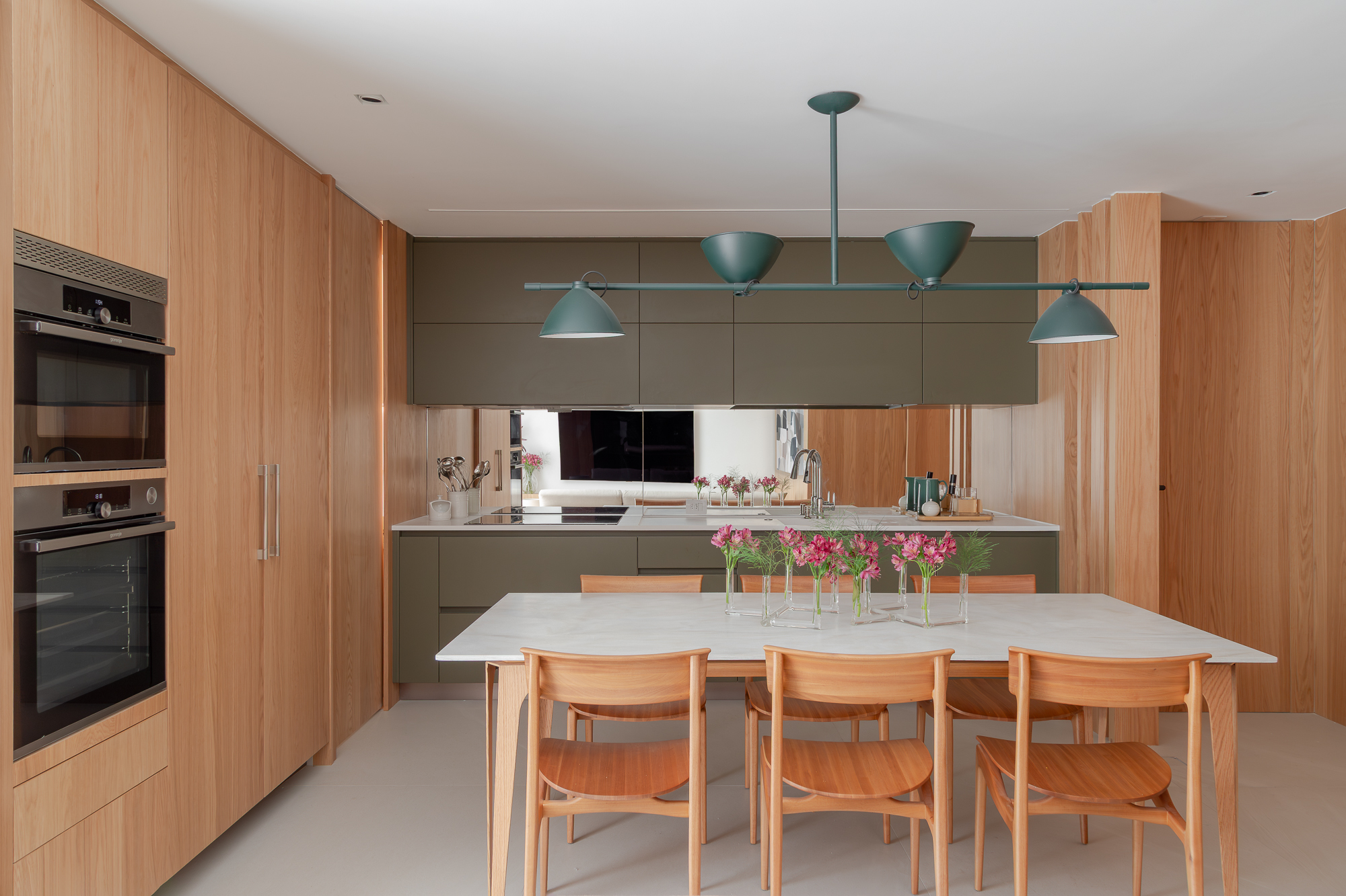 Varanda, estar, jantar e cozinha se integram neste apartamento de 97 m². Projeto de Paula Muller. Na foto, cozinha com marcenaria verde.